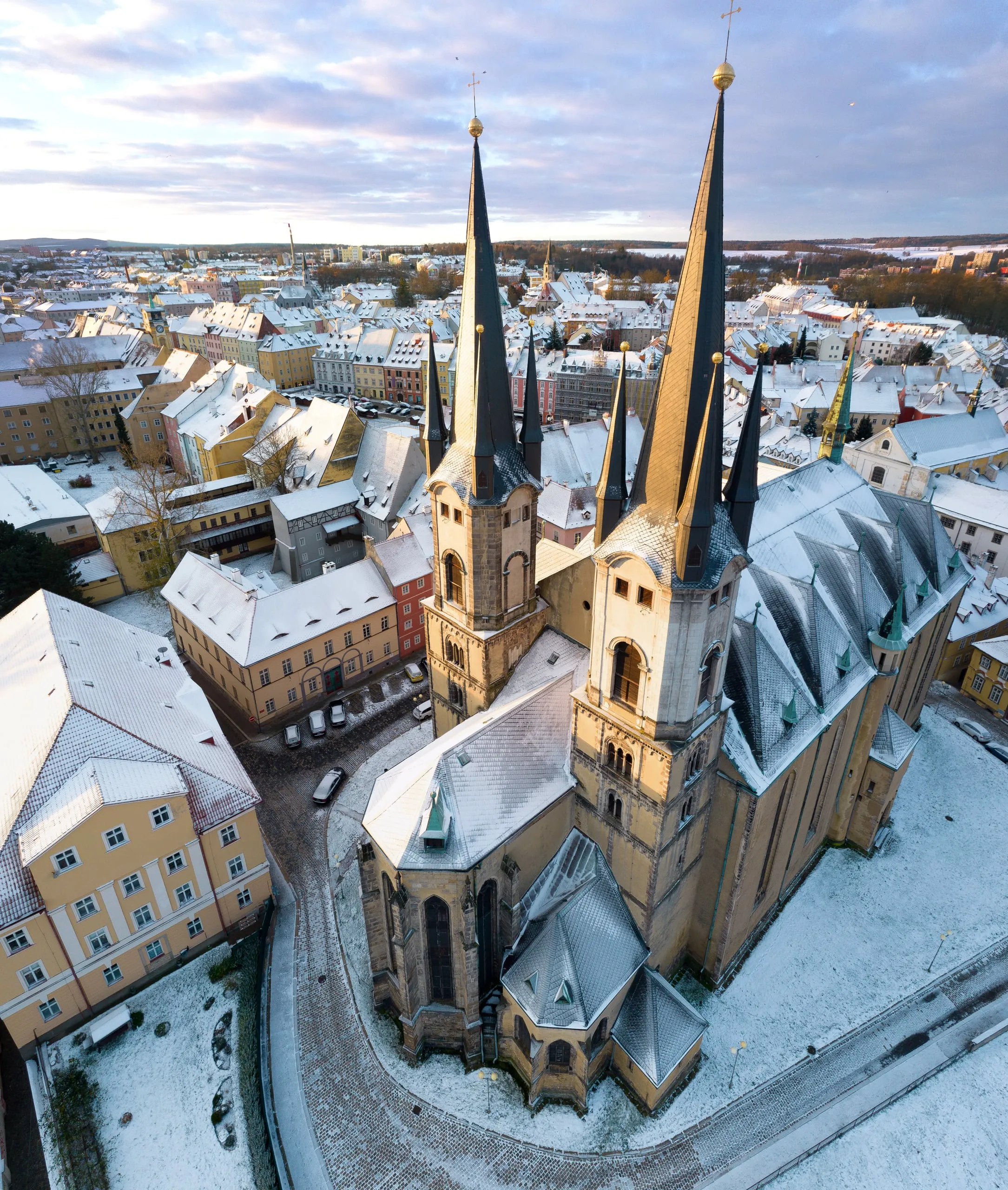 The Church of St Nicholas and St Elizabeth with its two slender spires and the snowy roofs of Cheb in the morning
