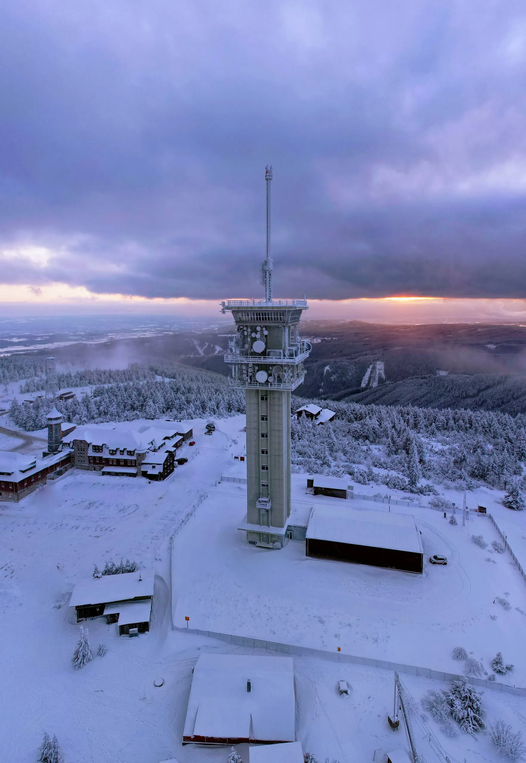 The television tower on the snowy summit of Klínovec at dusk