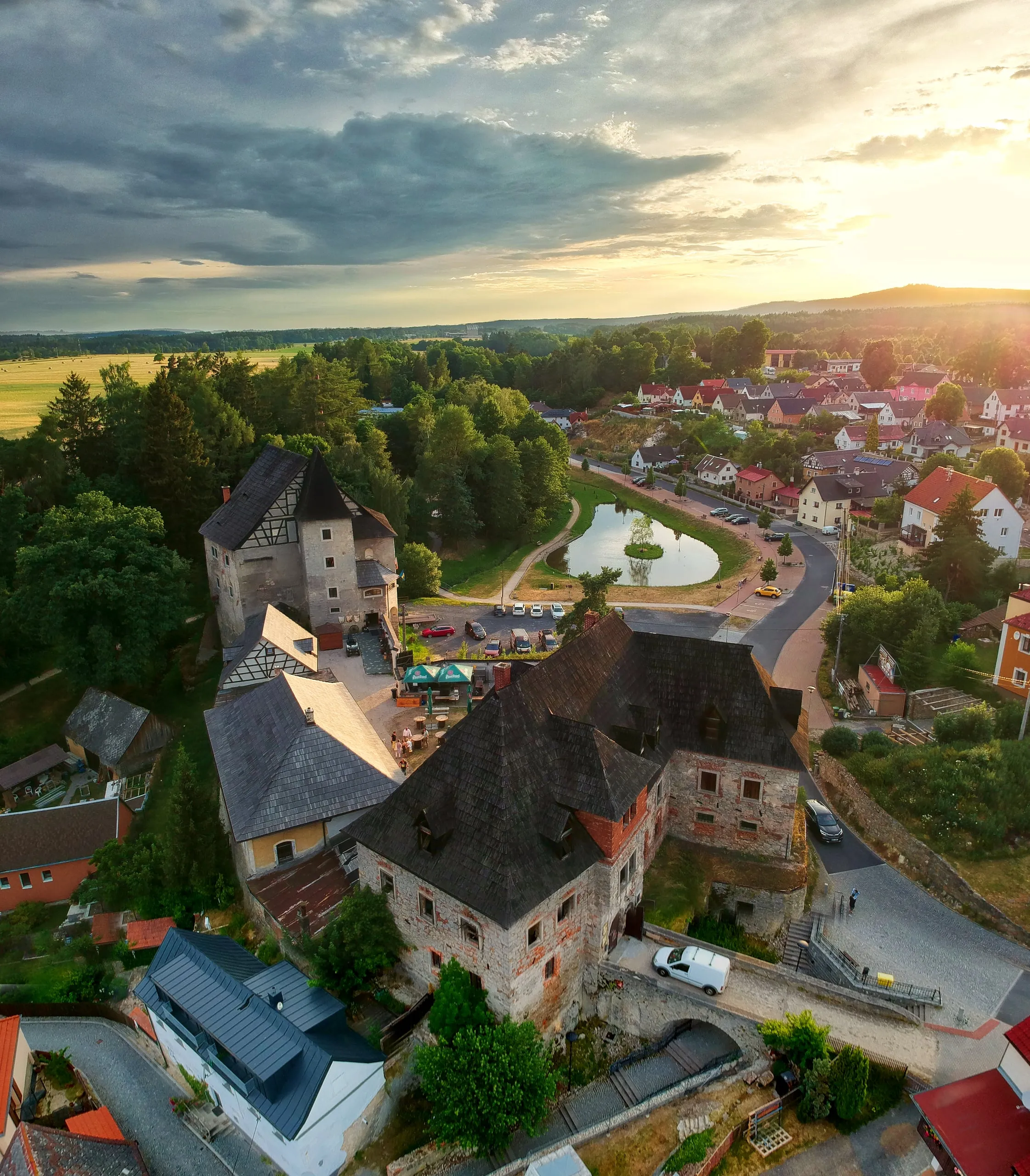 Vildštejn Castle with its tall roofs above Skalná at sunset