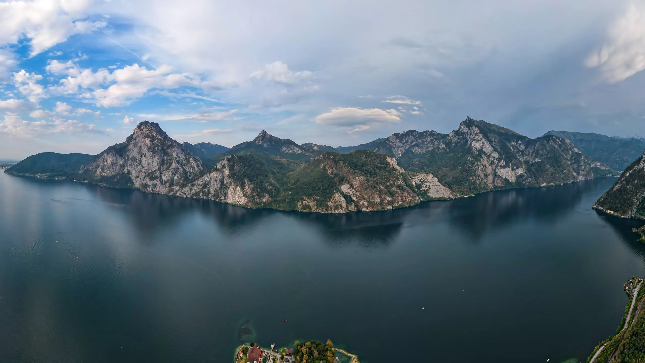 The dark Traunsee below a rocky ridge