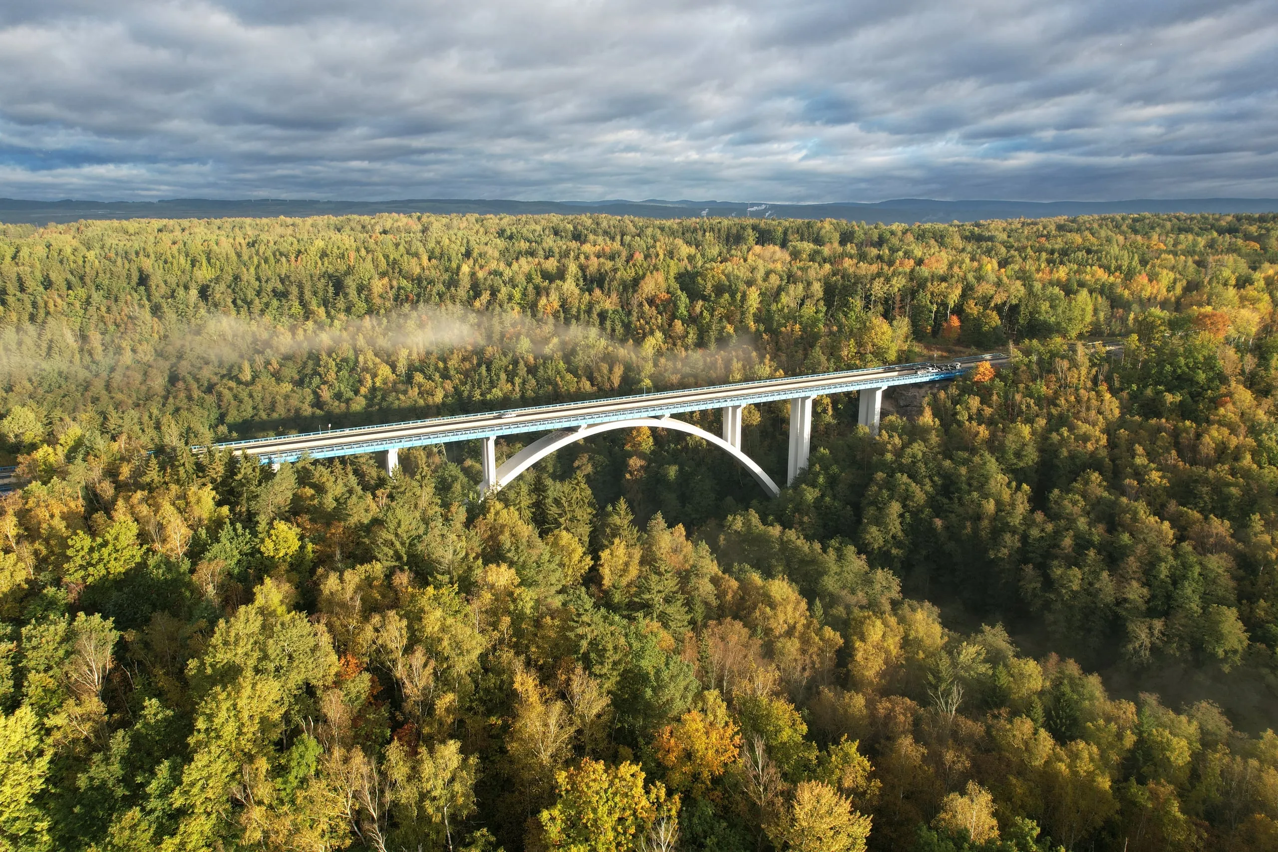 Freedom Bridge, an arch bridge across a valley in a forest of autumn colours near Sokolov