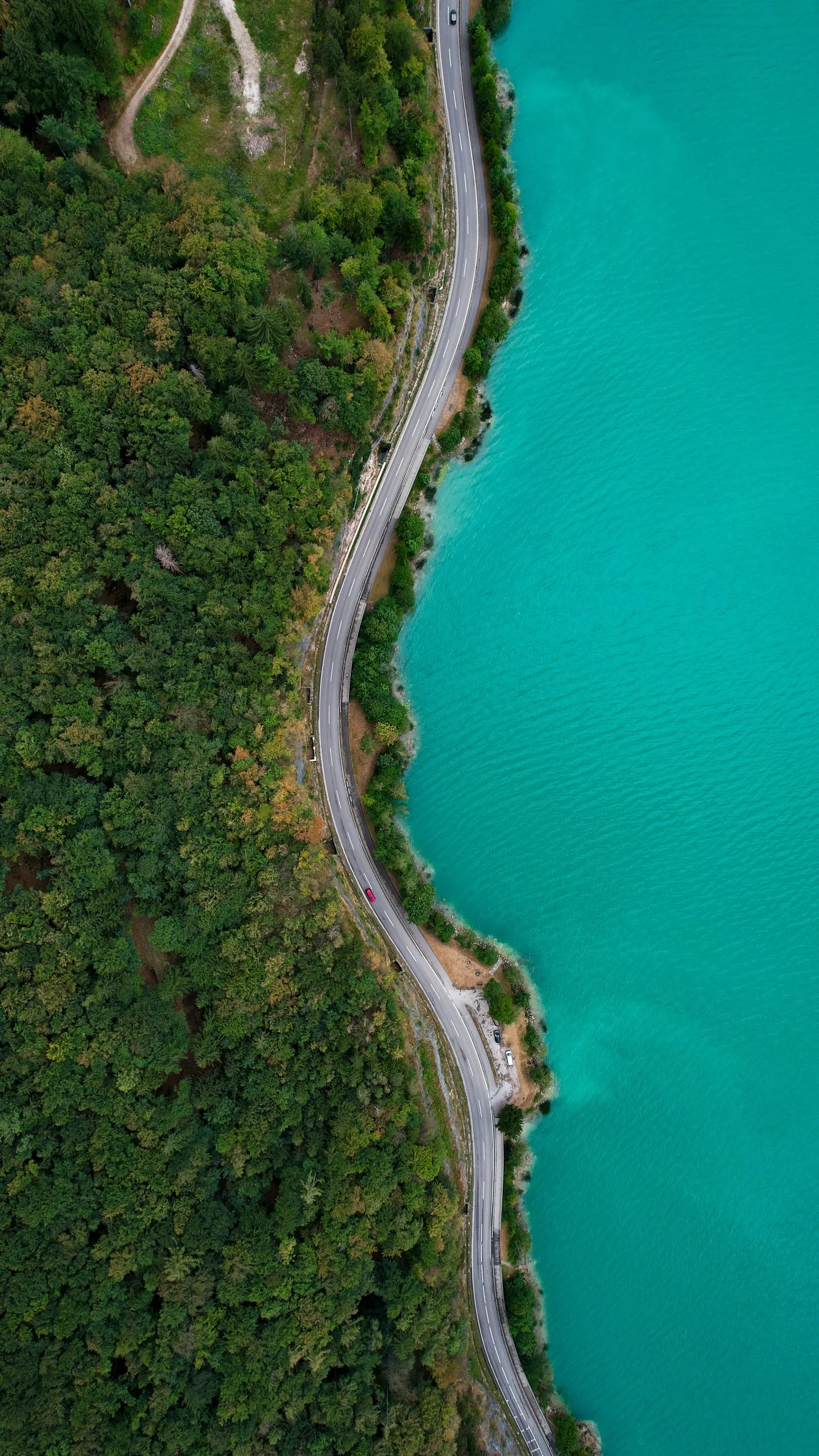 A road along the shore of the turquoise Mondsee, from straight above