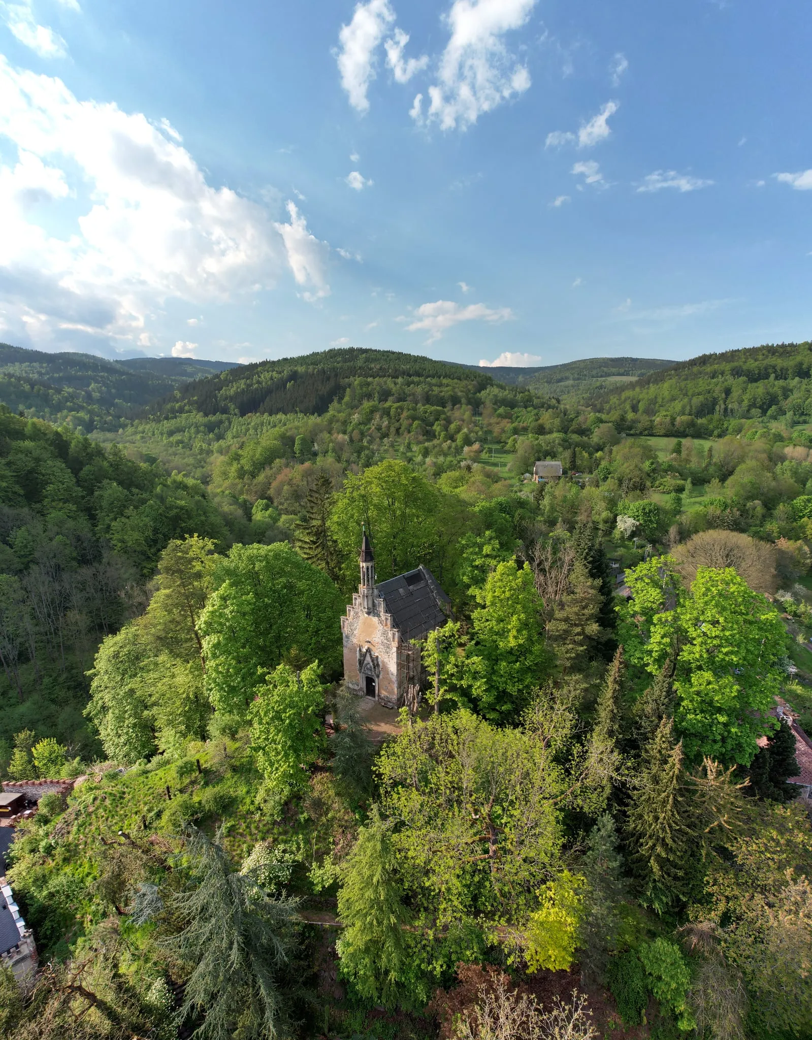 The chapel of Horní hrad (Hauenstein) hidden in the treetops on a wooded knoll