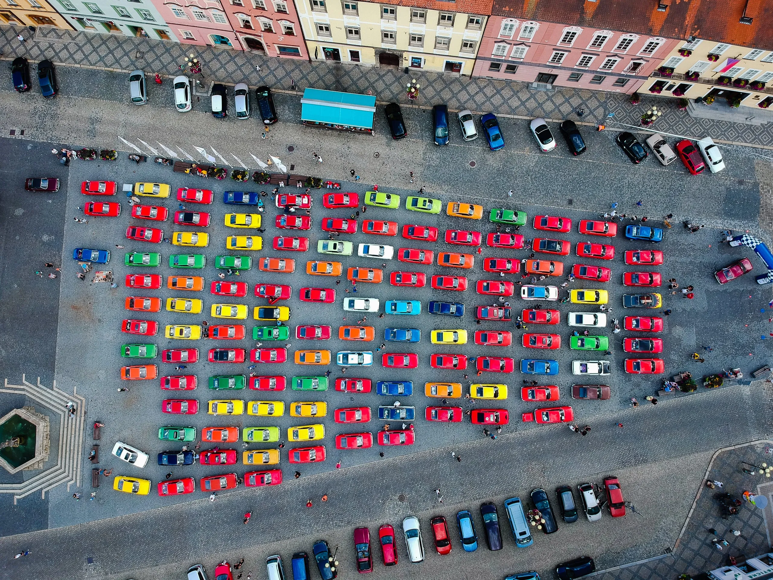 A town square filled with brightly coloured cars, from straight above