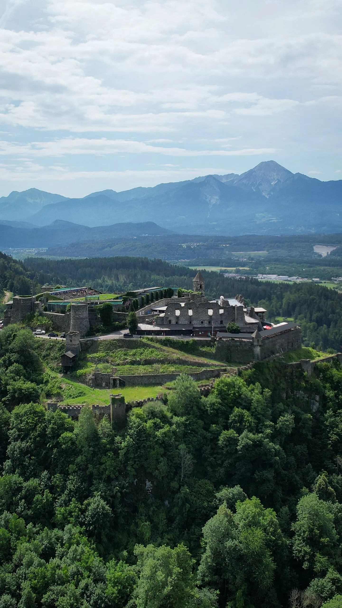A sprawling fortress on a hill in Austria, a mountain ridge on the horizon